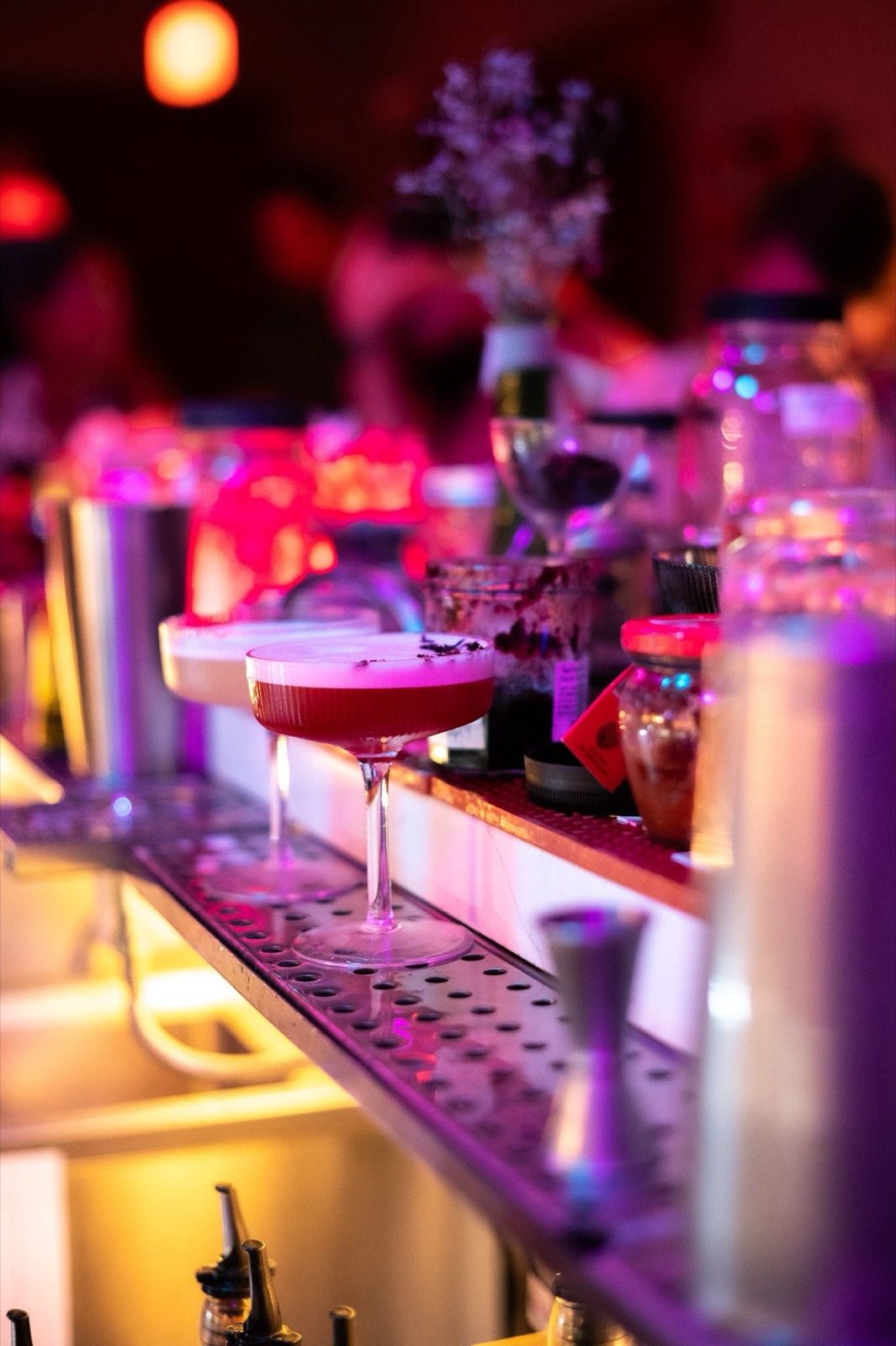 A cocktail on the bar among candles and flowers