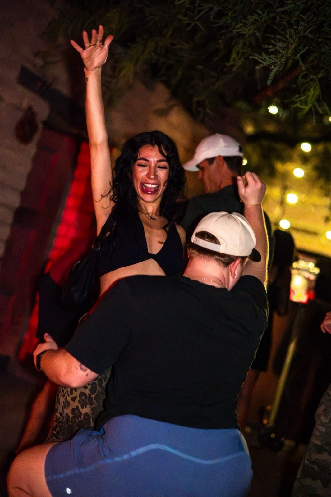 A joyful couple dancing at the reception, one arm raised