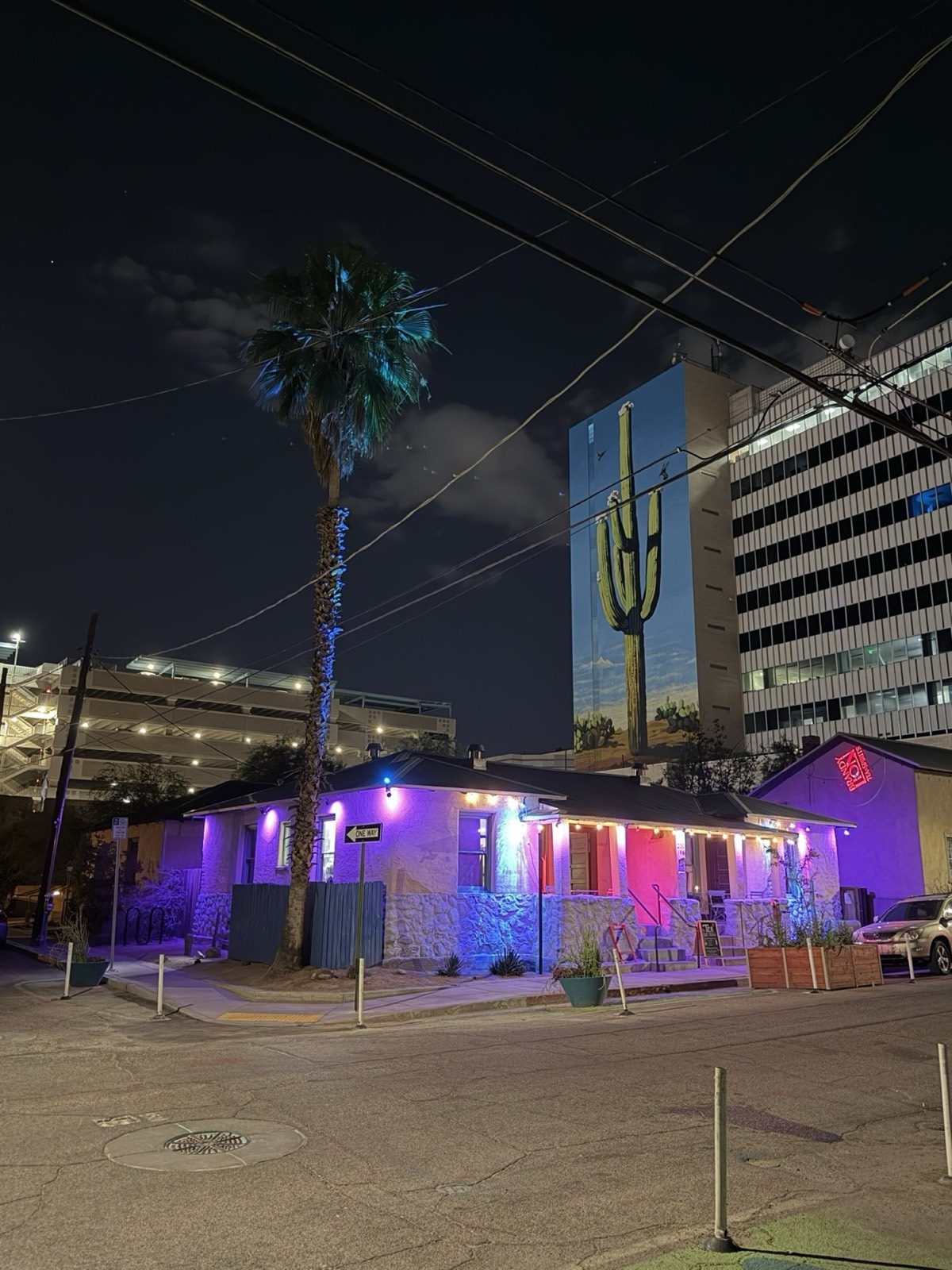 The Brandylion building corner lit pink and purple at night