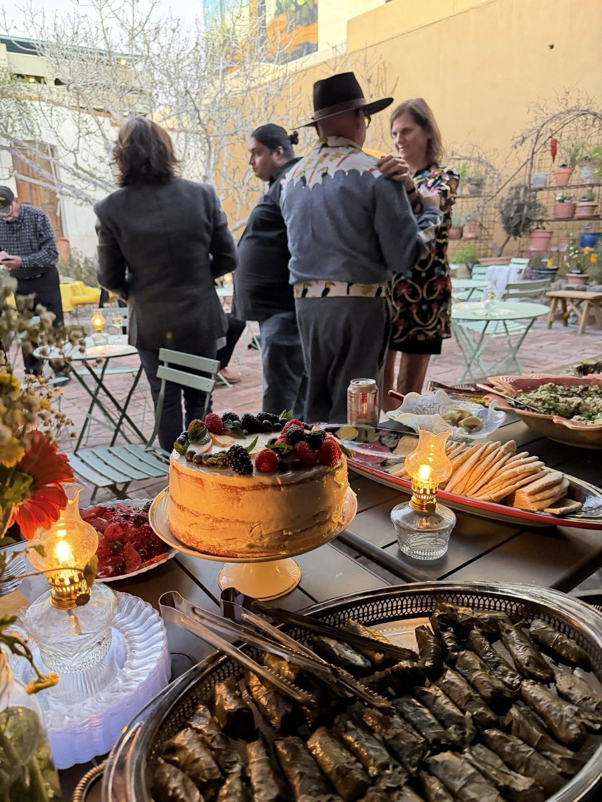 A celebration cake and food spread by candlelight