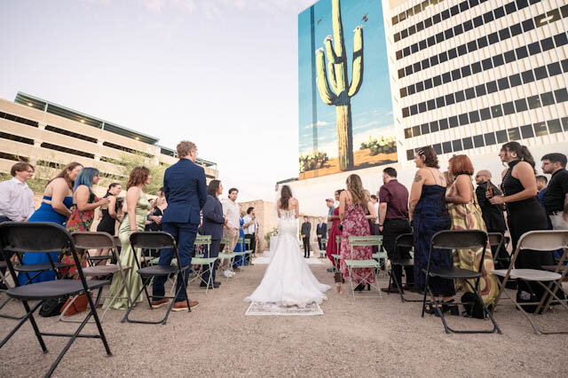 Guests seated for a ceremony with the downtown skyline above the courtyard