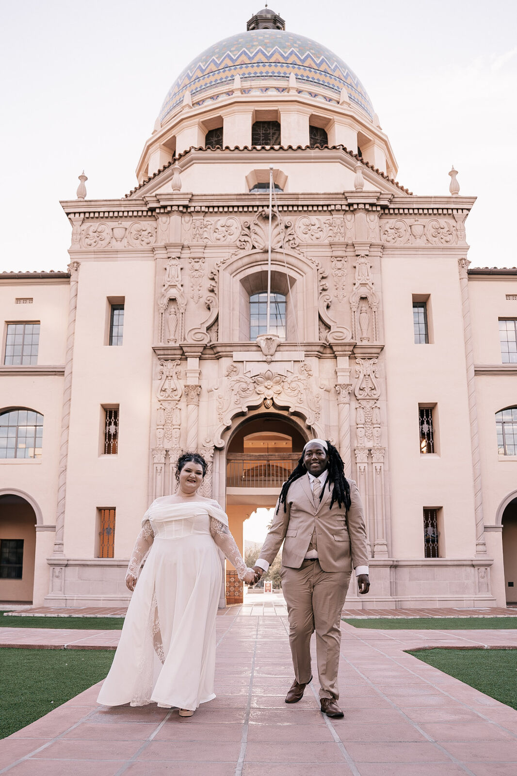 A couple walking out of the Pima County Courthouse under its tiled dome