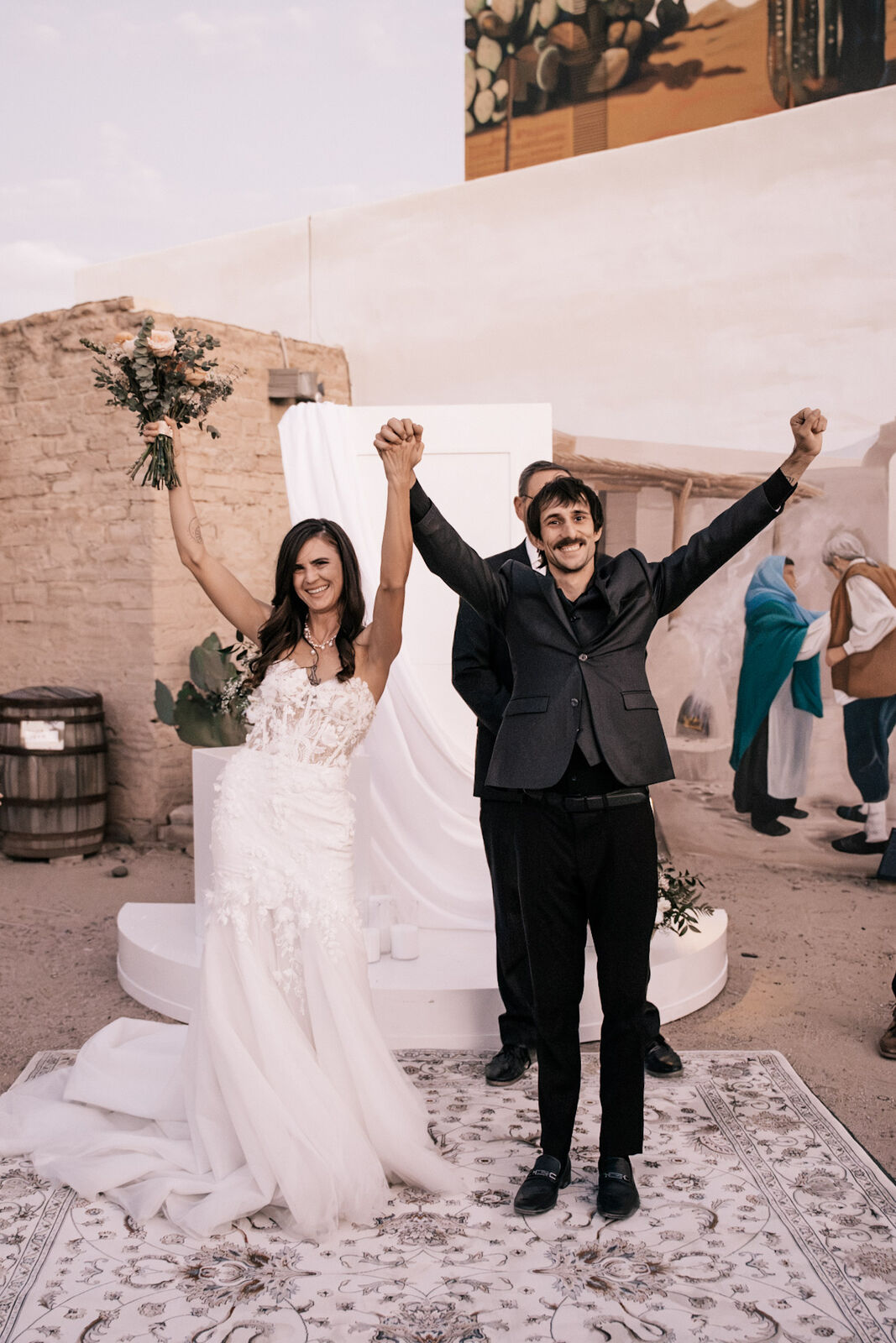 The couple throwing their arms up after the ceremony