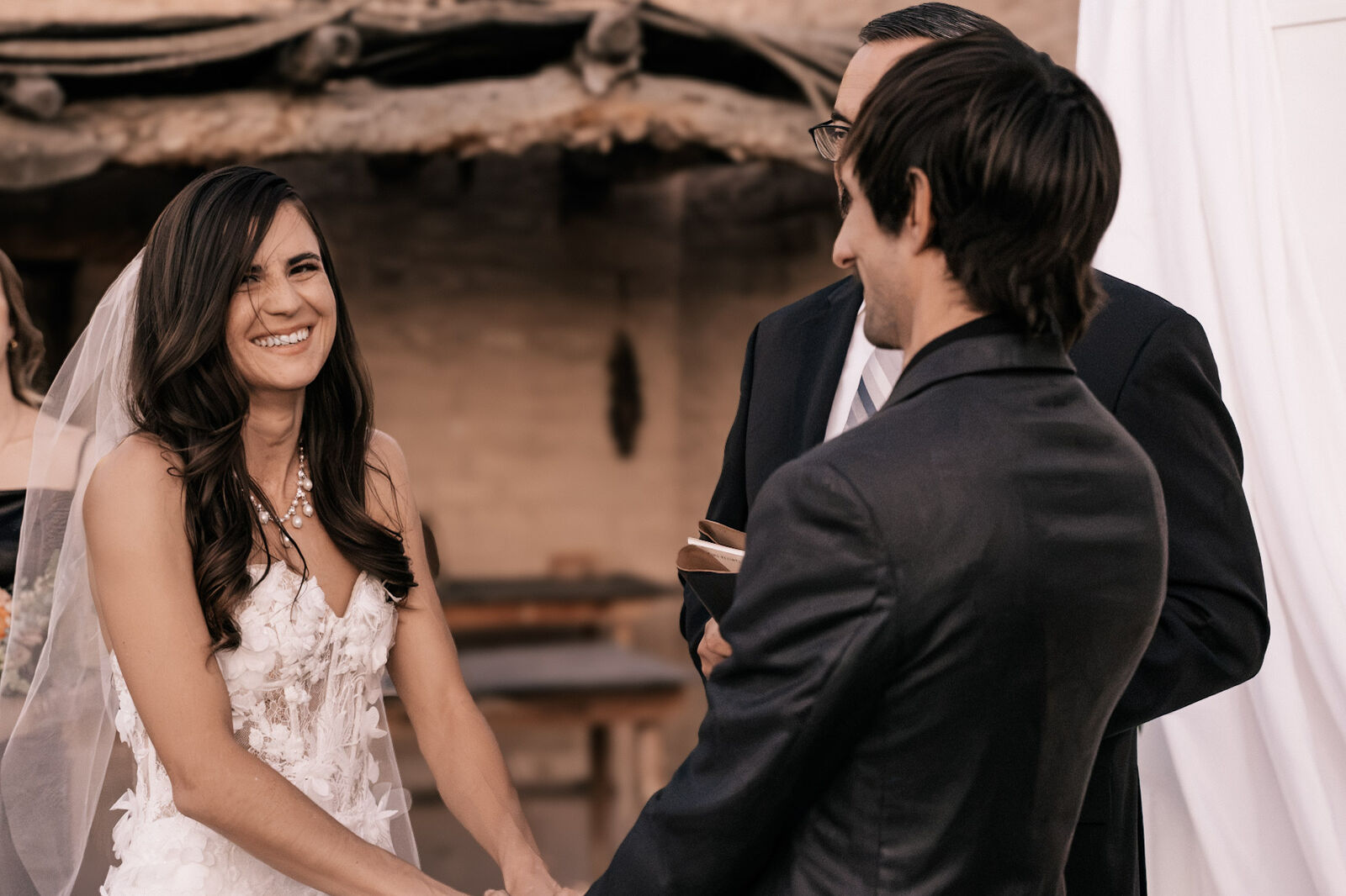 A bride laughing during the vows