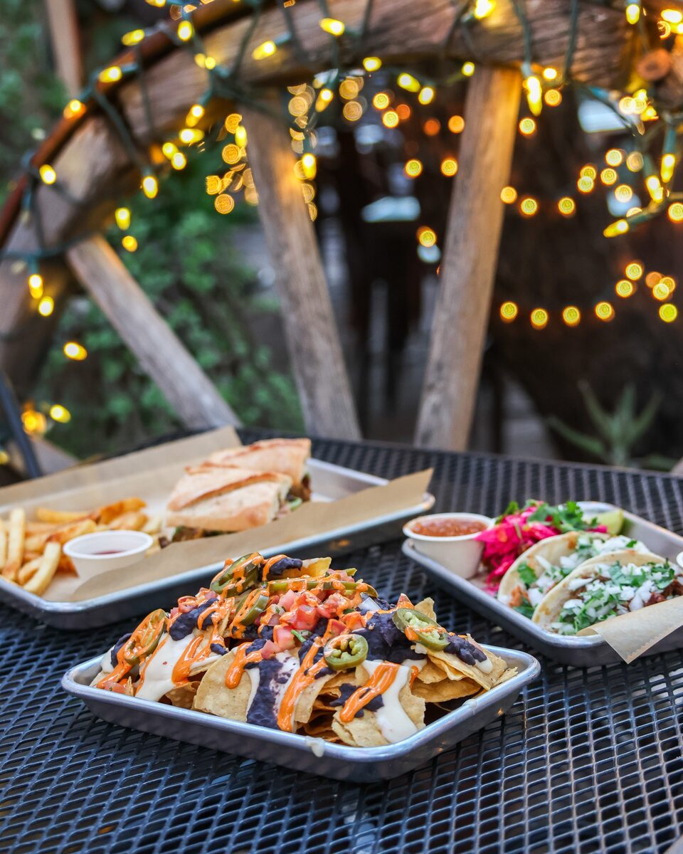 Nachos, tacos and a sandwich on a patio table at JoJo’s