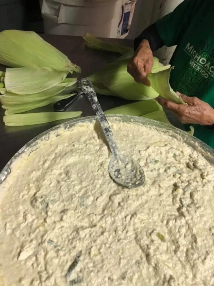 Hands folding fresh tamales from a bowl of masa at La Indita